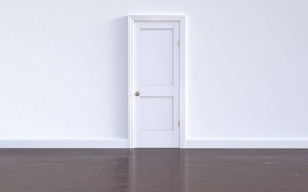 White door with white wall and wooden floor